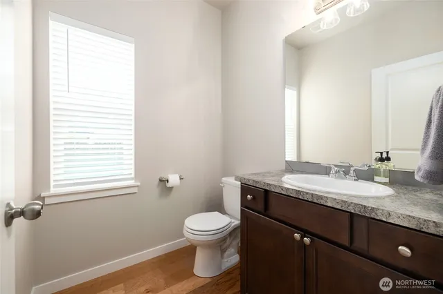 a bathroom with a granite countertop toilet a sink and a mirror