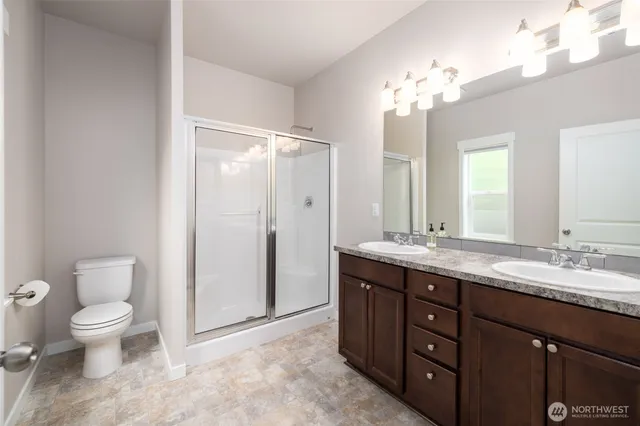 a spacious bathroom with a double vanity sink toilet and a mirror