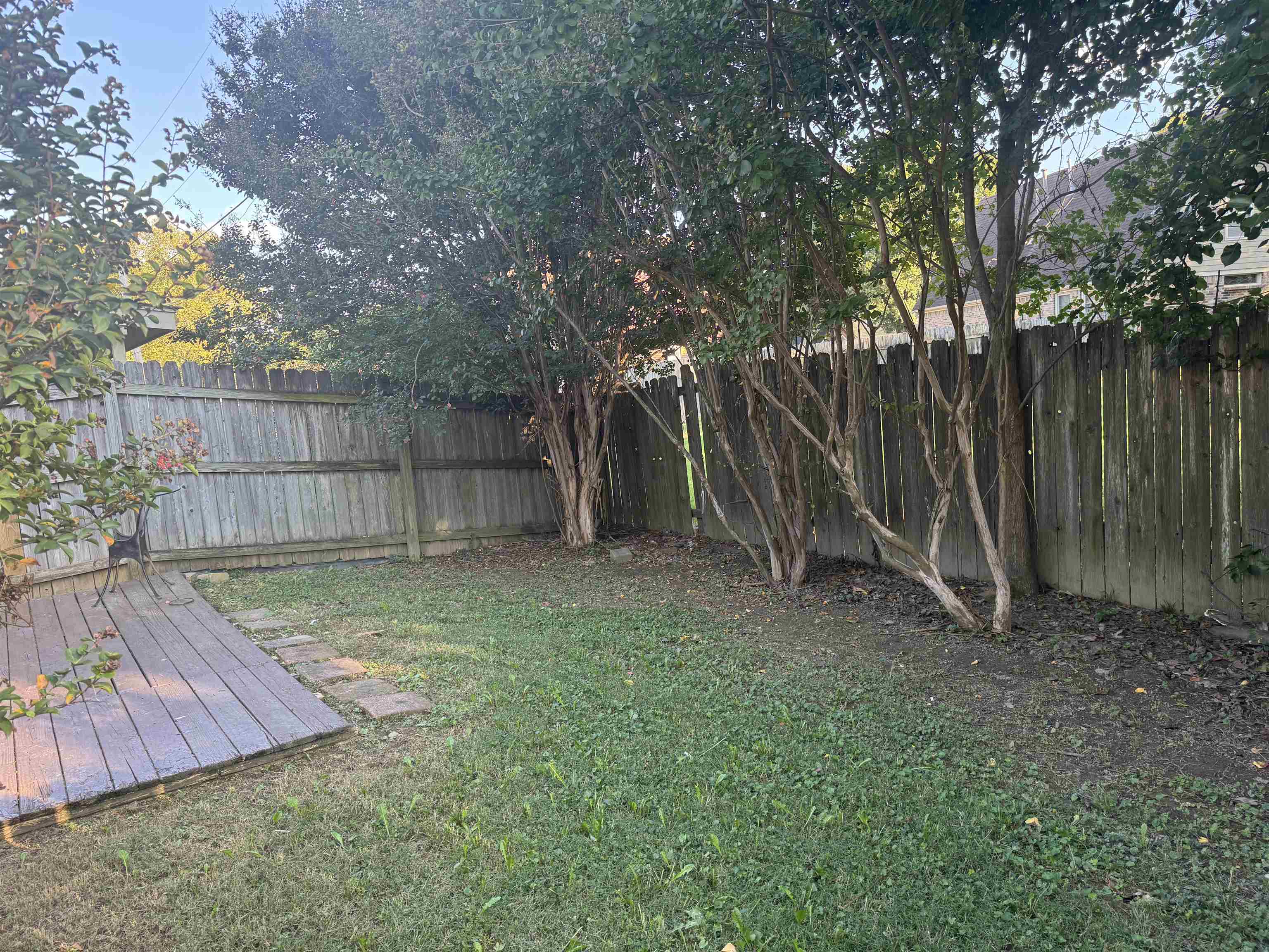 6893 Snyder Road Memphis, TN 38141 - Photo 13 of 13 a view of a backyard with large trees and wooden fence