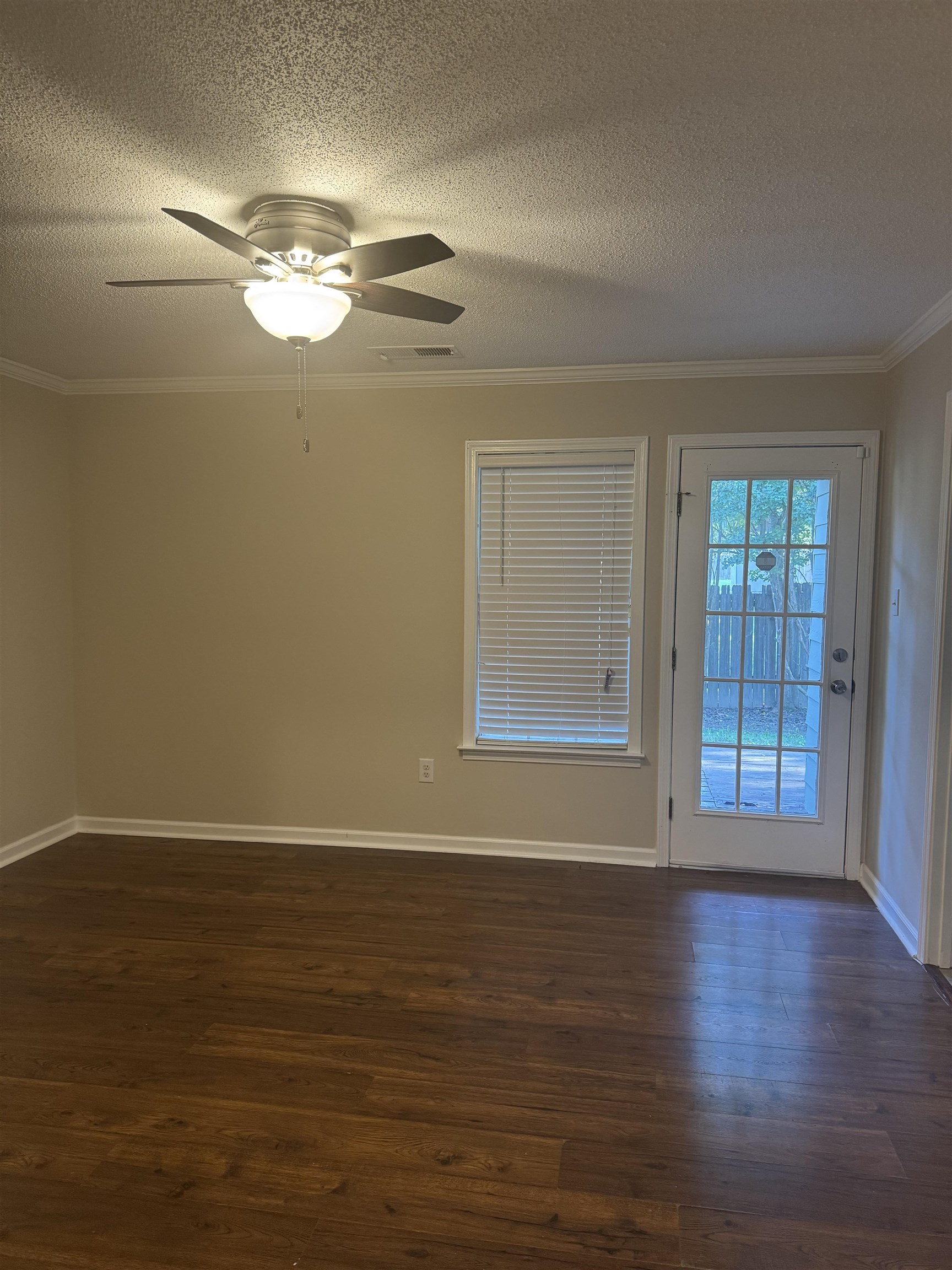 6893 Snyder Road Memphis, TN 38141 - Photo 8 of 13 a view of an empty room with wooden floor and a window