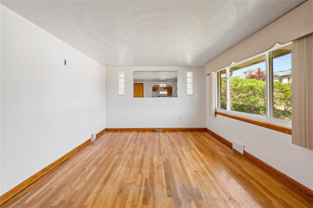 223 Washington Avenue Homestead, PA 15120 - Photo 6 of 31 a view of an empty room with wooden floor and a window