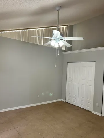 an empty room with a chandelier fan