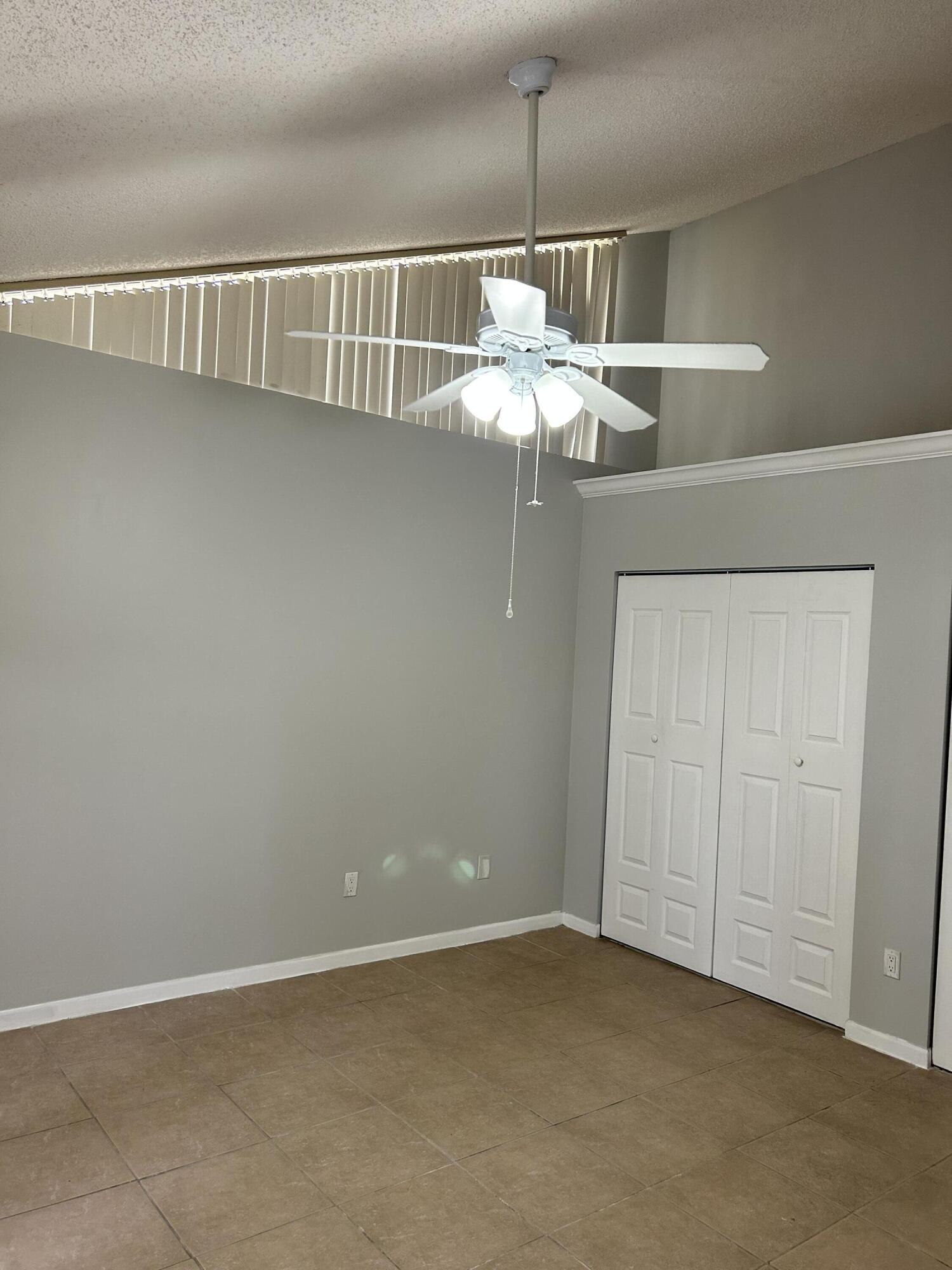 1158 Summit Trail Circle, Unit D West Palm Beach, FL 33415 - Photo 2 of 10 an empty room with a chandelier fan
