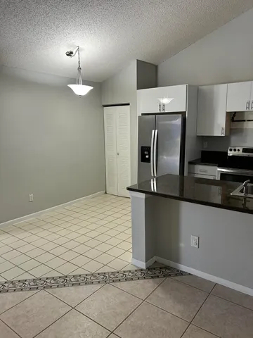 a kitchen with granite countertop a refrigerator a stove and a sink