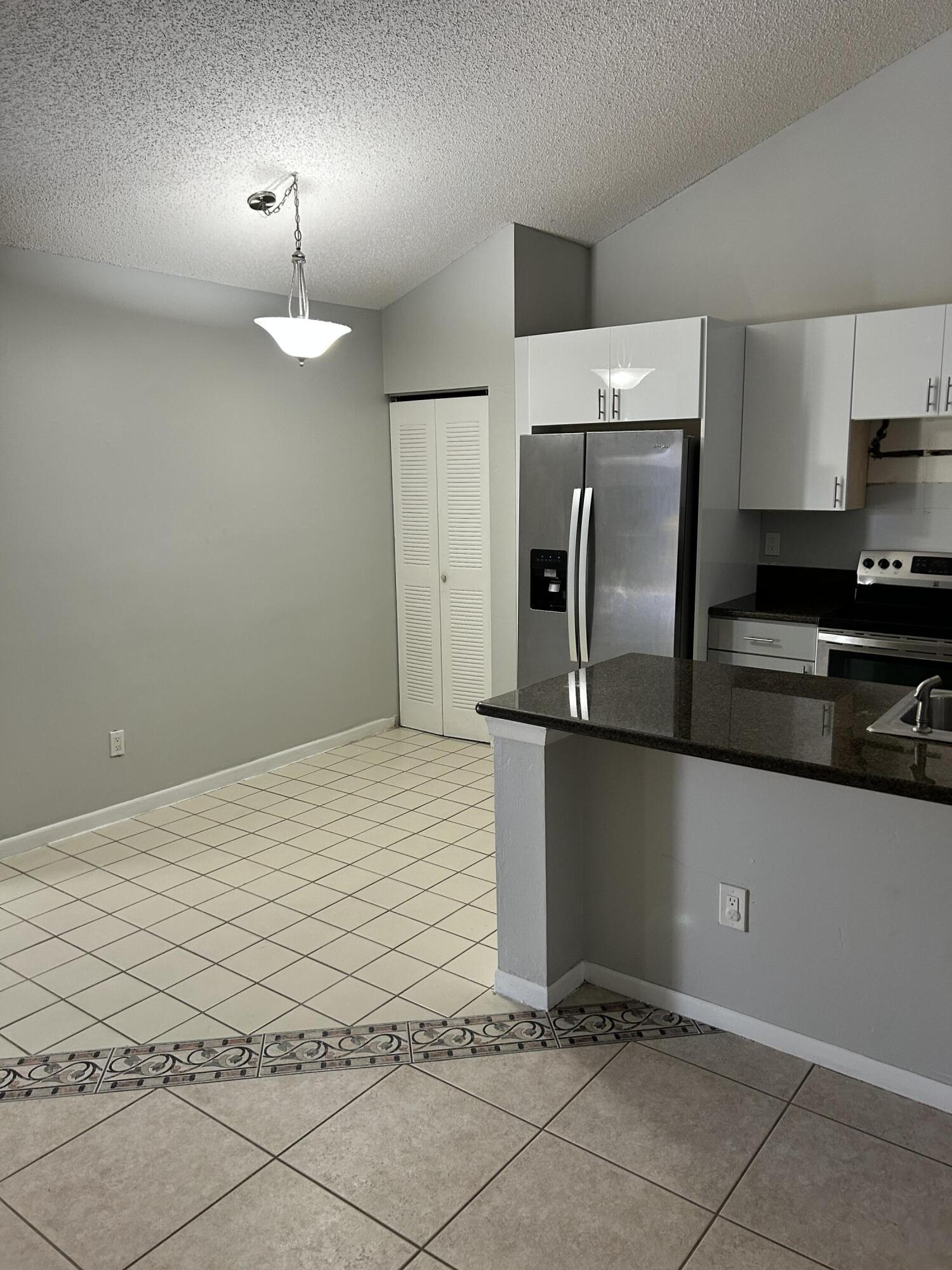1158 Summit Trail Circle, Unit D West Palm Beach, FL 33415 - Photo 4 of 10 a kitchen with granite countertop a refrigerator a stove and a sink