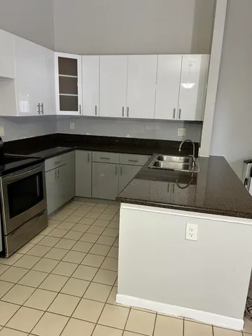 a kitchen with granite countertop a sink and a stove top oven