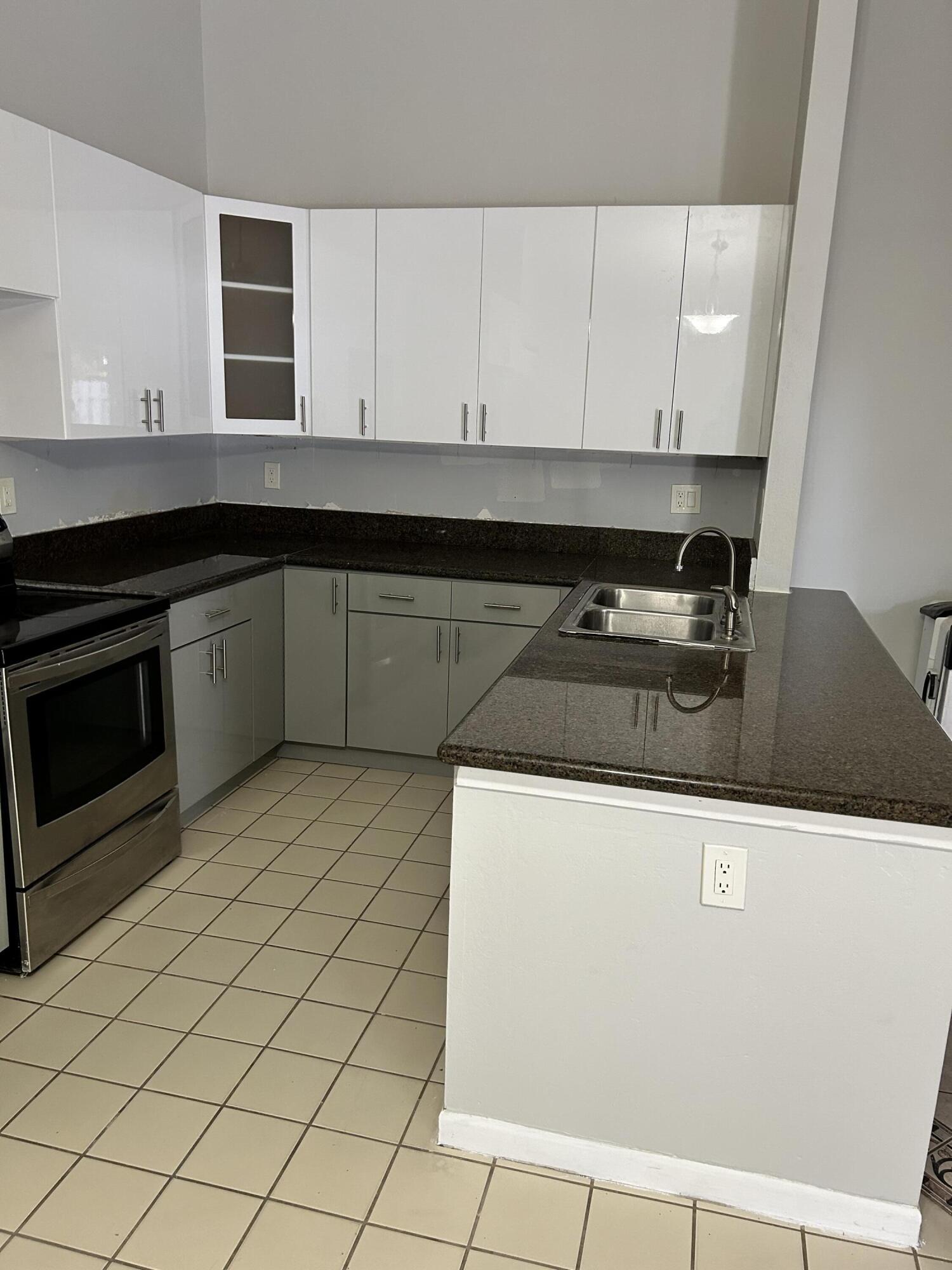 1158 Summit Trail Circle, Unit D West Palm Beach, FL 33415 - Photo 6 of 10 a kitchen with granite countertop a sink and a stove top oven