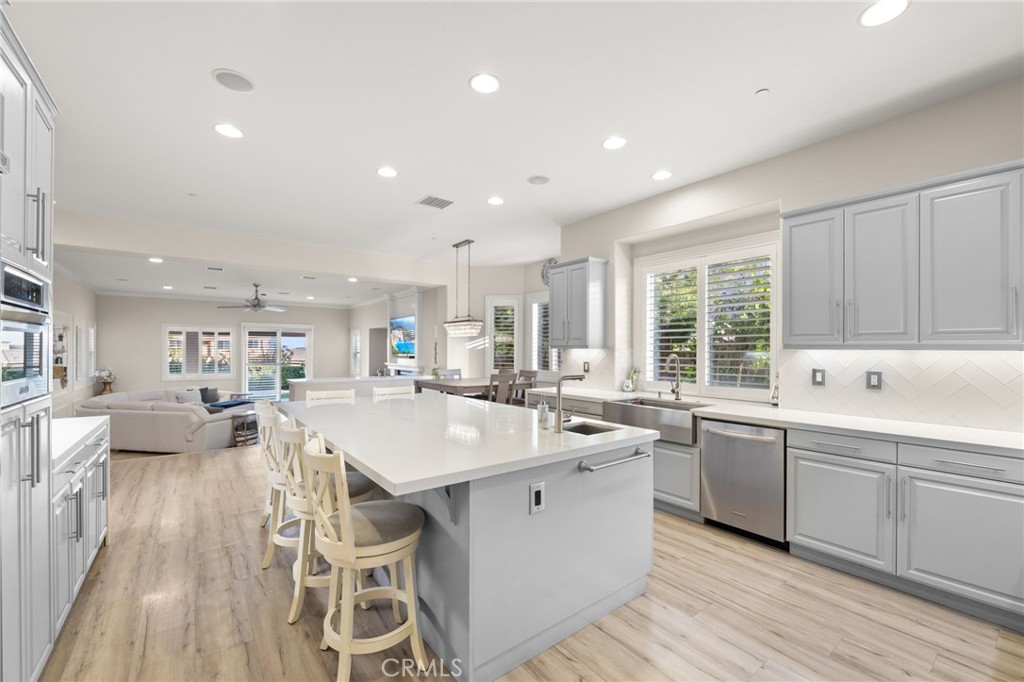 4947 Palomino Place Rancho Cucamonga, CA 91737 - Photo 14 of 53 a large kitchen with kitchen island a sink table and chairs