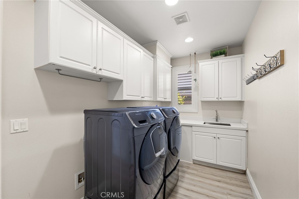 4947 Palomino Place Rancho Cucamonga, CA 91737 - Photo 23 of 53 a utility room with cabinets washer and dryer