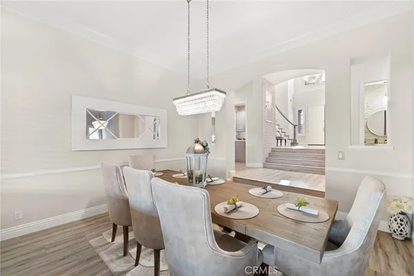 a dining room with stainless steel appliances wooden floors a table and chairs