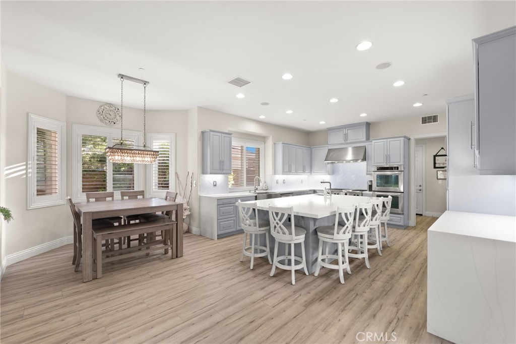 4947 Palomino Place Rancho Cucamonga, CA 91737 - Photo 10 of 53 a dining room with stainless steel appliances wooden floors a table and chairs
