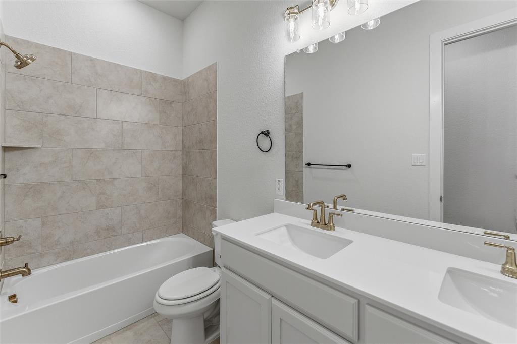 2208 Continent Court Krum, TX 76249 - Photo 16 of 26 Full bathroom featuring a dual vanity with white cabinetry and integrated sinks, complemented by a large mirror and five-light vanity fixture