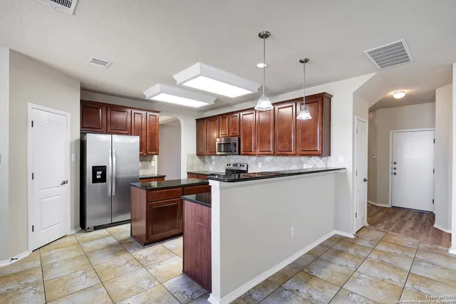a kitchen with stainless steel appliances granite countertop a refrigerator and a sink