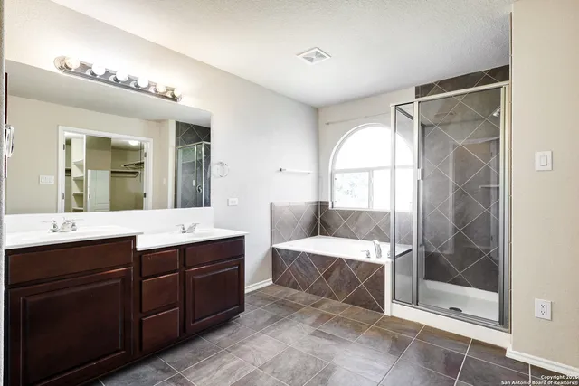 a spacious bathroom with a shower sink and mirror