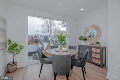 a dining room with furniture potted plants and wooden floor