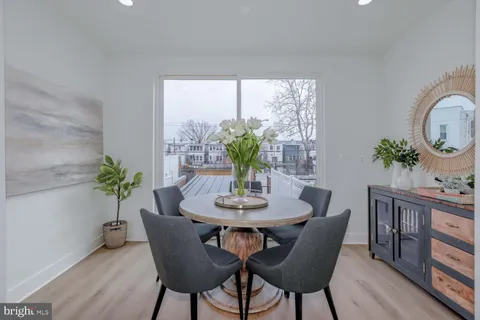 a dining room with furniture potted plants and wooden floor