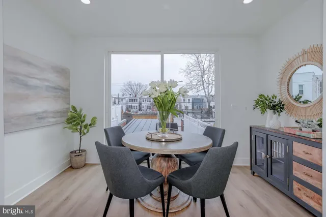 a dining room with furniture potted plants and wooden floor