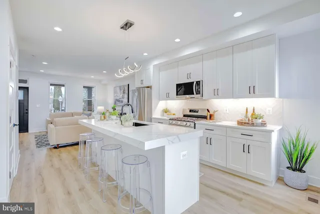 a kitchen with white cabinets and sink