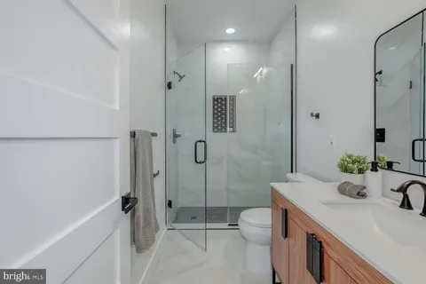 a bathroom with a sink toilet double vanity and shower