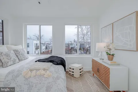 a bedroom with a bed and large window
