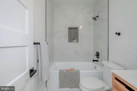 a bathroom with a toilet and a bath tub