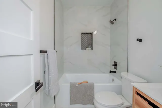 a bathroom with a toilet and a bath tub