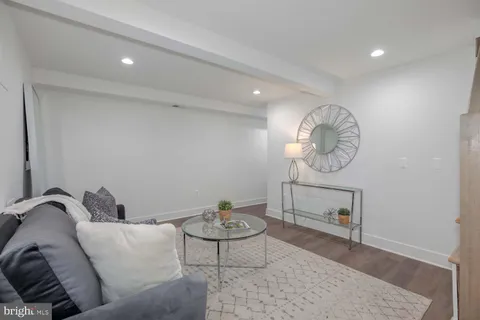 a living room with furniture a rug and white walls