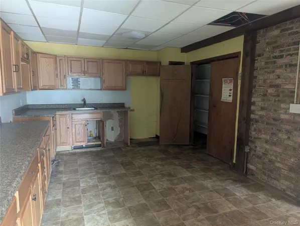 a kitchen with a sink a refrigerator and cabinets