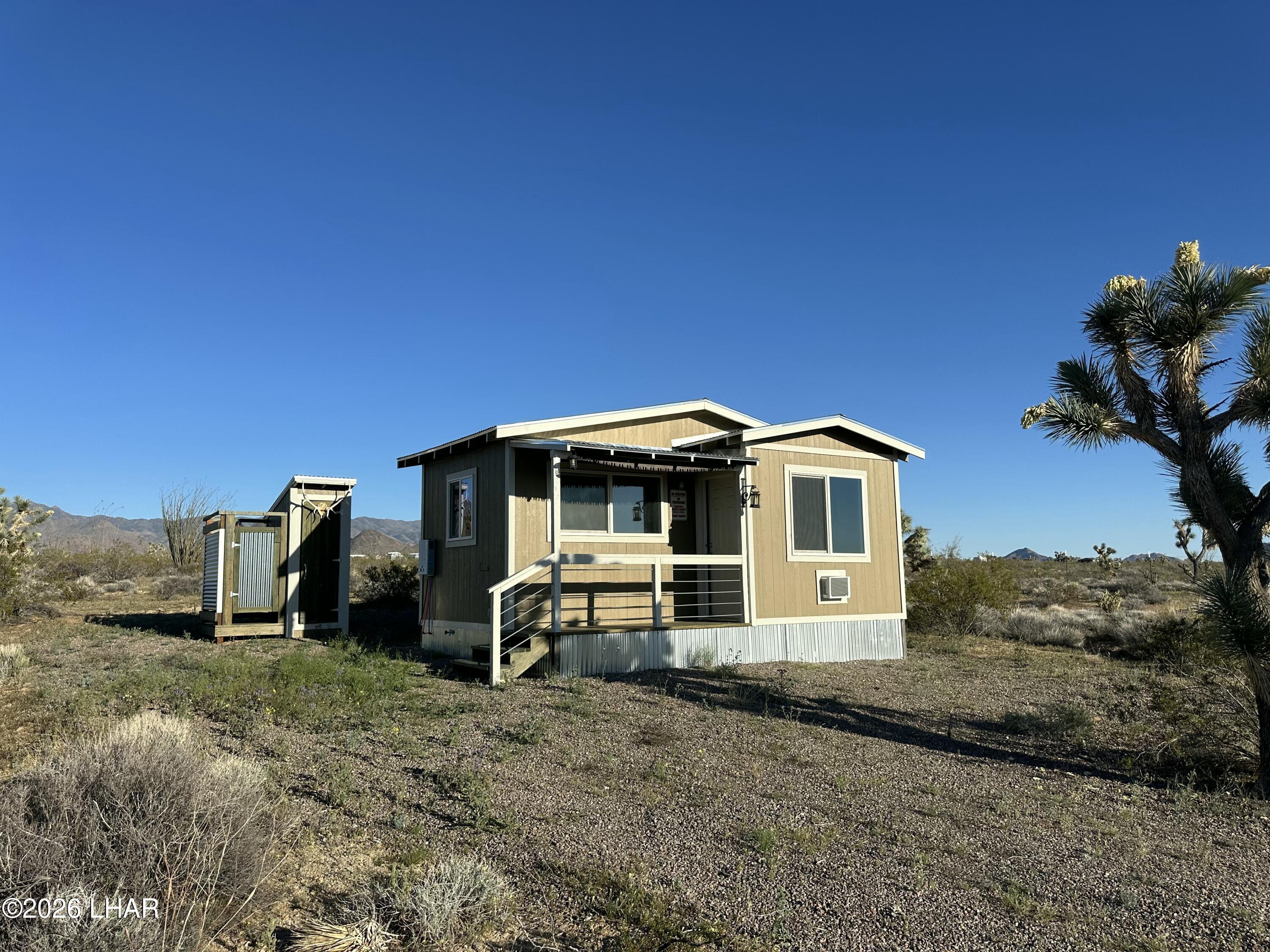 122 South Carrow Road Yucca, AZ 86438 - Photo 1 of 47 a front view of a house with a yard