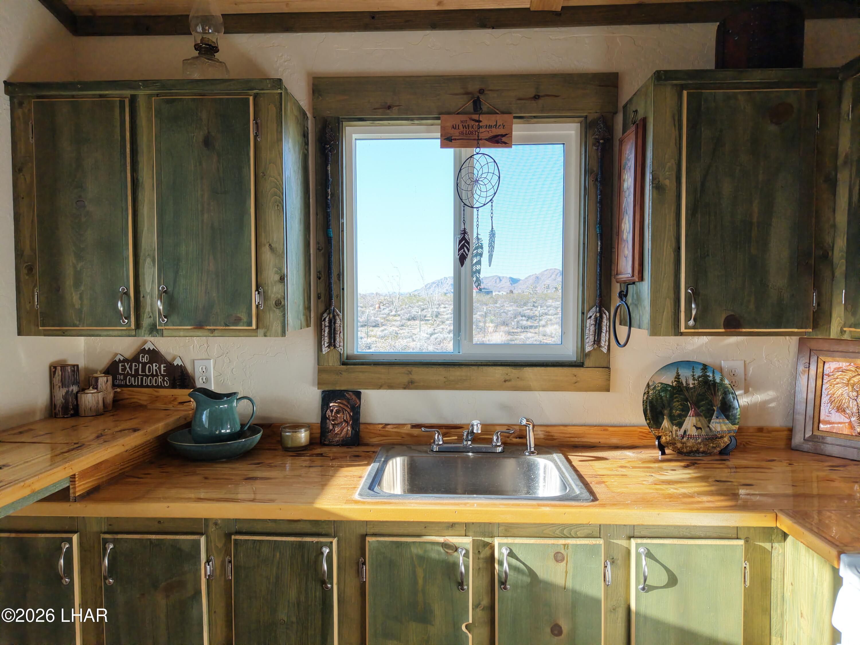 122 South Carrow Road Yucca, AZ 86438 - Photo 28 of 47 a kitchen with a sink a window and cabinets