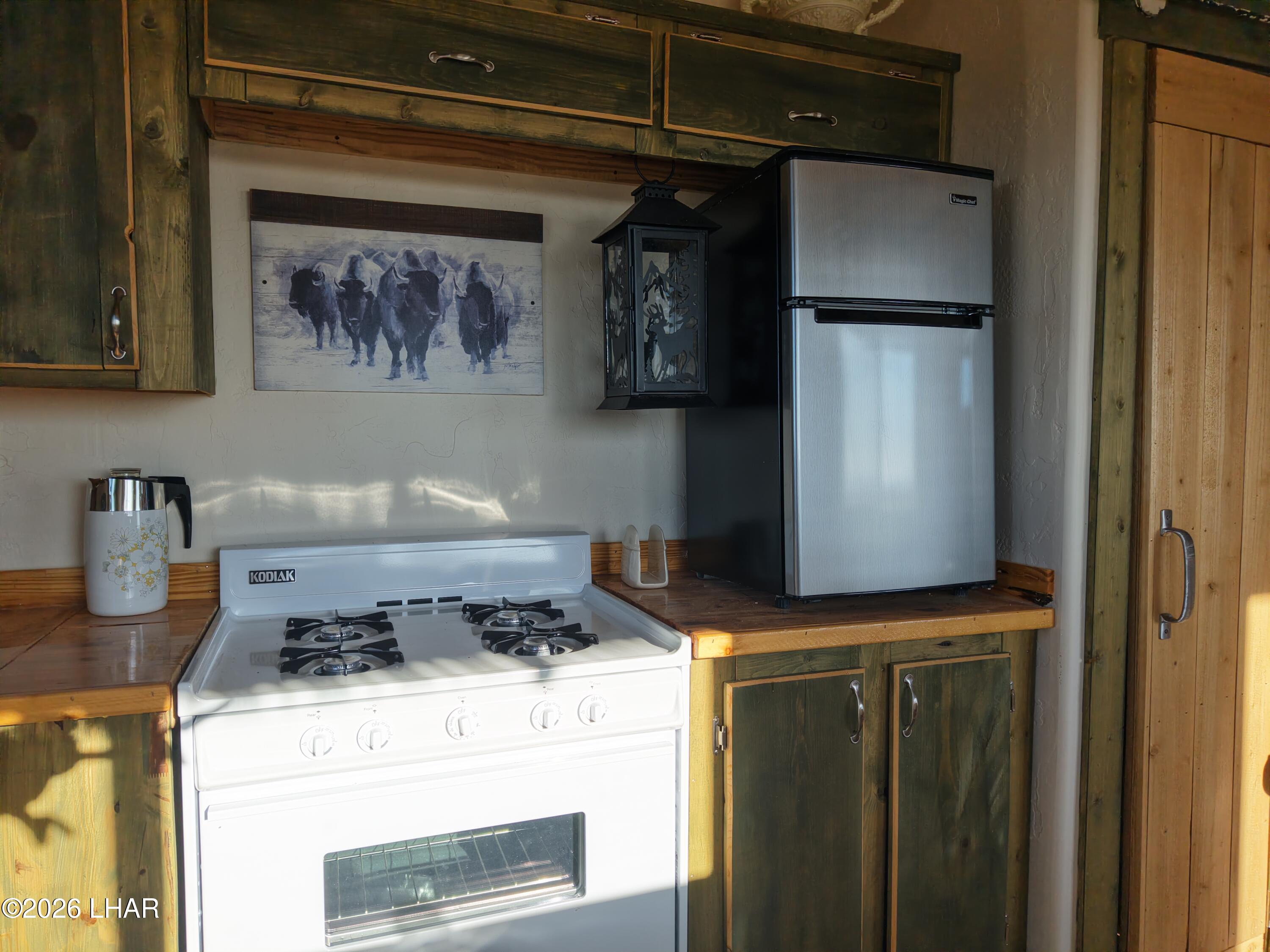 122 South Carrow Road Yucca, AZ 86438 - Photo 29 of 47 a kitchen with a refrigerator and a stove