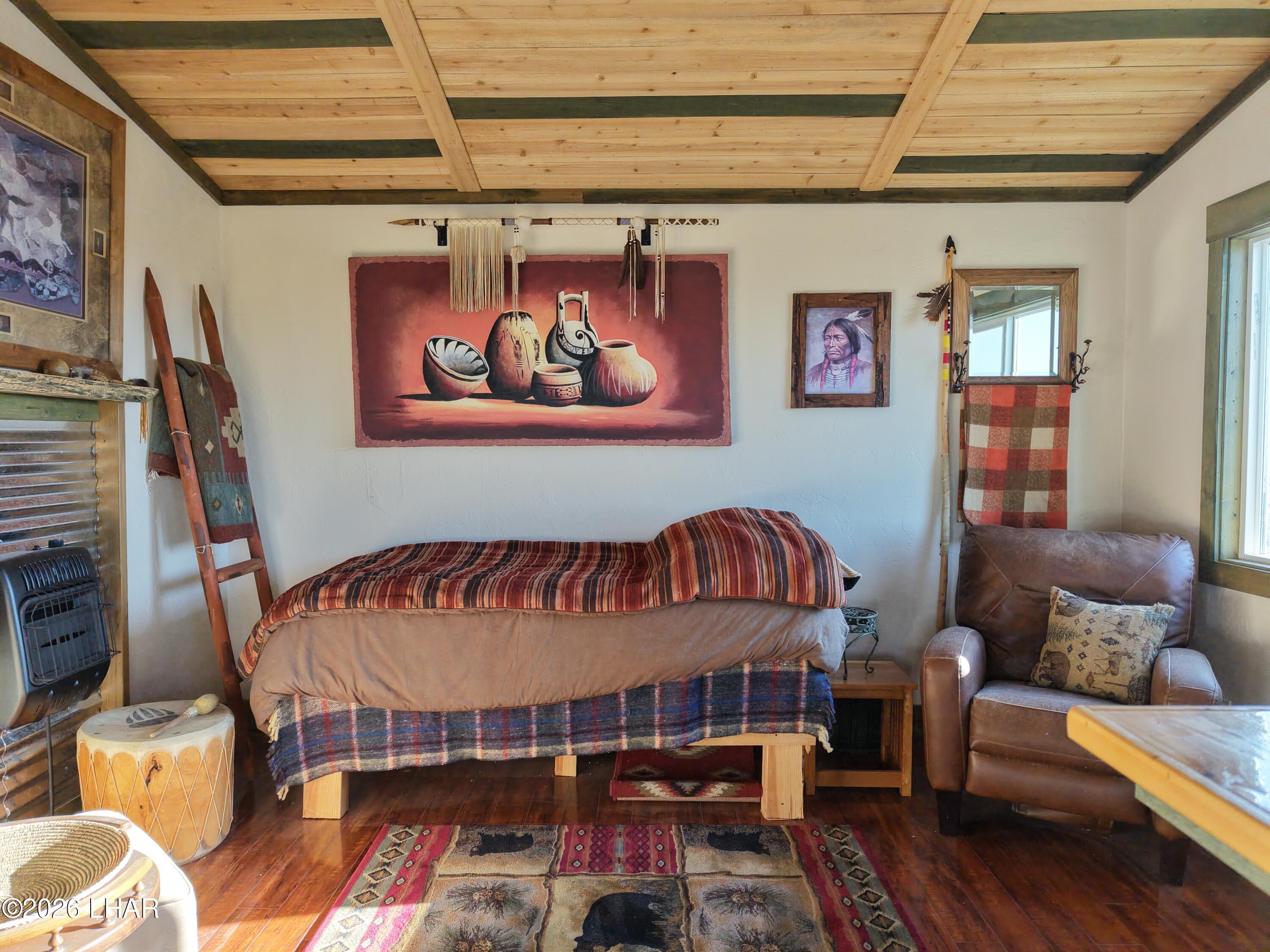 122 South Carrow Road Yucca, AZ 86438 - Photo 31 of 47 a bedroom with furniture and a wooden floor