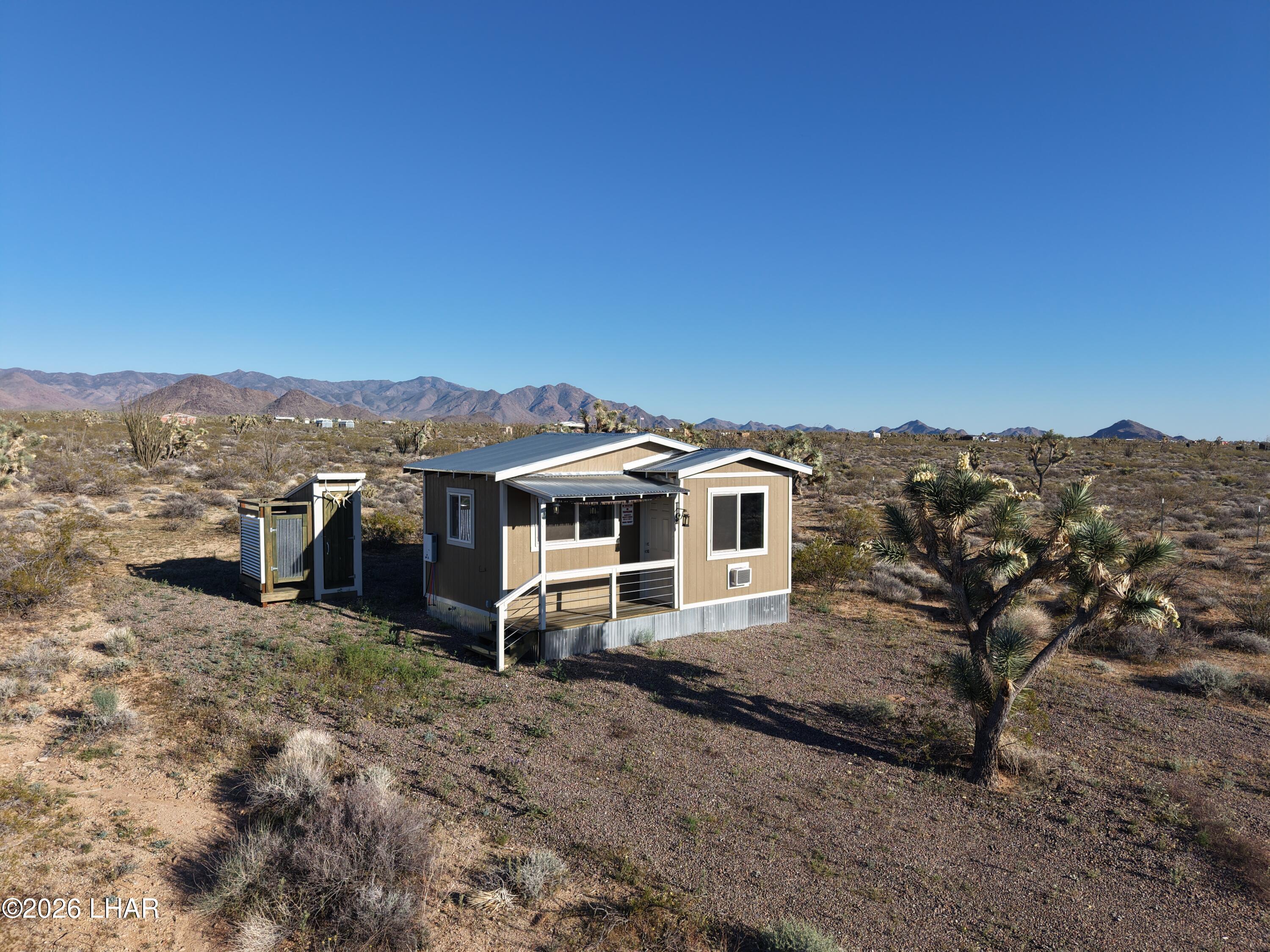 122 South Carrow Road Yucca, AZ 86438 - Photo 6 of 47 a view of a big house with a mountain in the background