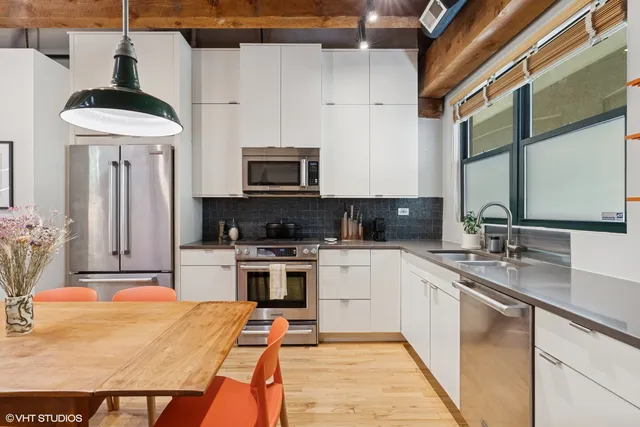 a kitchen with stainless steel appliances kitchen island granite countertop a sink a stove and cabinets