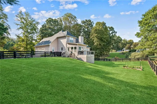 a white house with a small yard and big trees