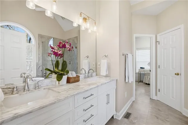 a bathroom with a granite countertop sink a mirror and a shower
