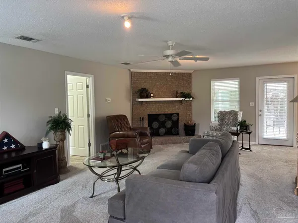 a living room with furniture a fireplace and a window