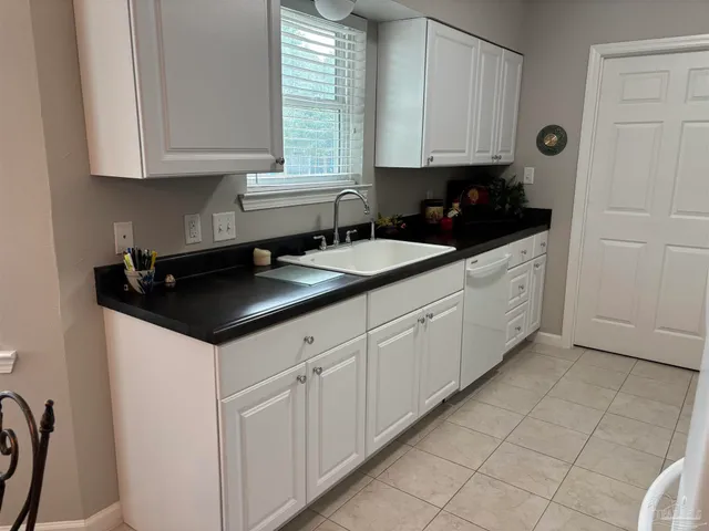 a kitchen with granite countertop white cabinets and sink