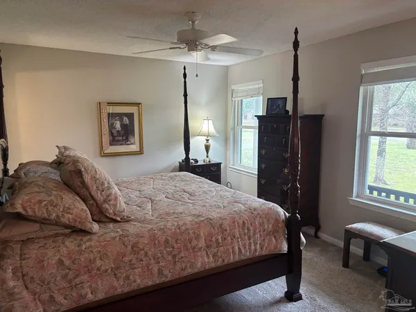 a bedroom with a bed dresser and a window
