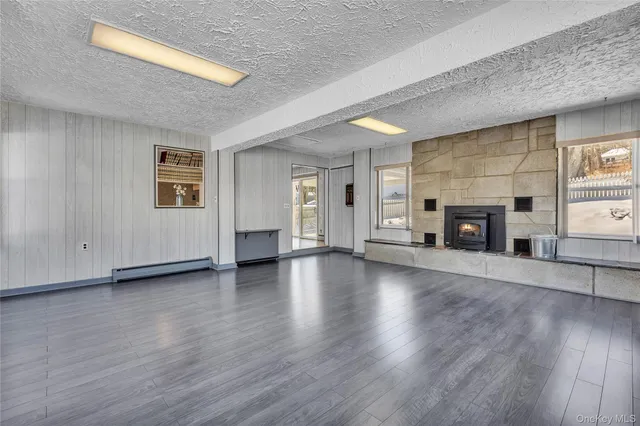 a view of a livingroom with wooden floor and a fireplace