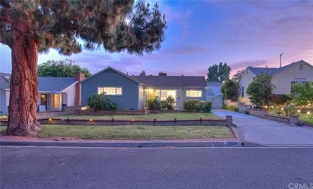 a view of a house with a yard and a street