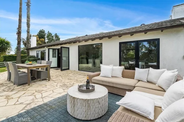 a view of a patio with couches chairs dining table and chairs with wooden floor