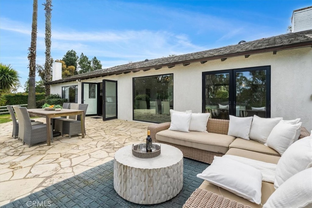 a view of a patio with couches chairs dining table and chairs with wooden floor