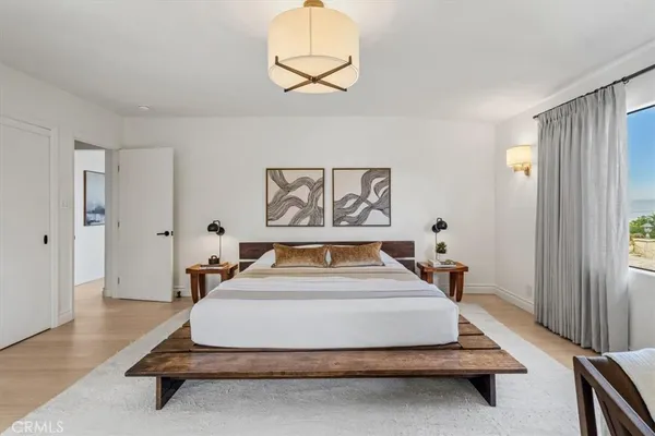 a spacious bedroom with a bed and a chandelier