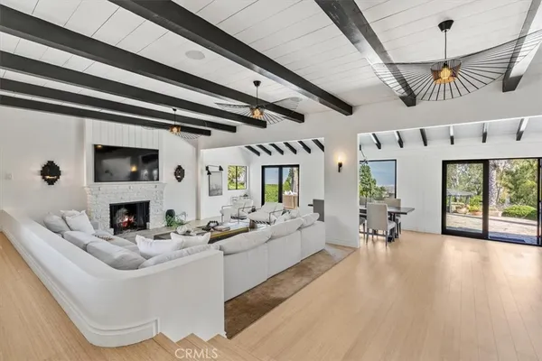 a living room with furniture large window and wooden floor