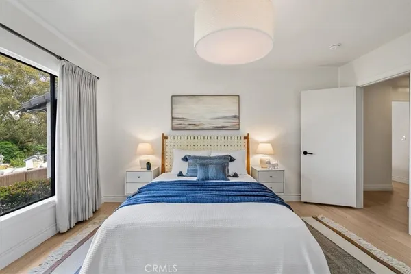 a view of a bedroom with wooden floor and a window