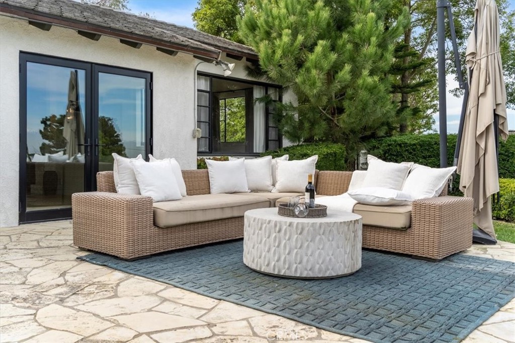 19 Wideloop Road Rolling Hills, CA 90274 - Photo 27 of 35 a view of a patio with couches and a table and chairs with wooden floor and fence