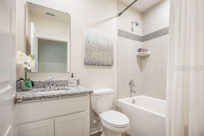 1407 Needle Palm Drive Edgewater, FL 32132 - Photo 16 of 28 a bathroom with a granite countertop sink a toilet a mirror and shower