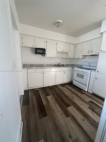 a kitchen with granite countertop white cabinets and white appliances