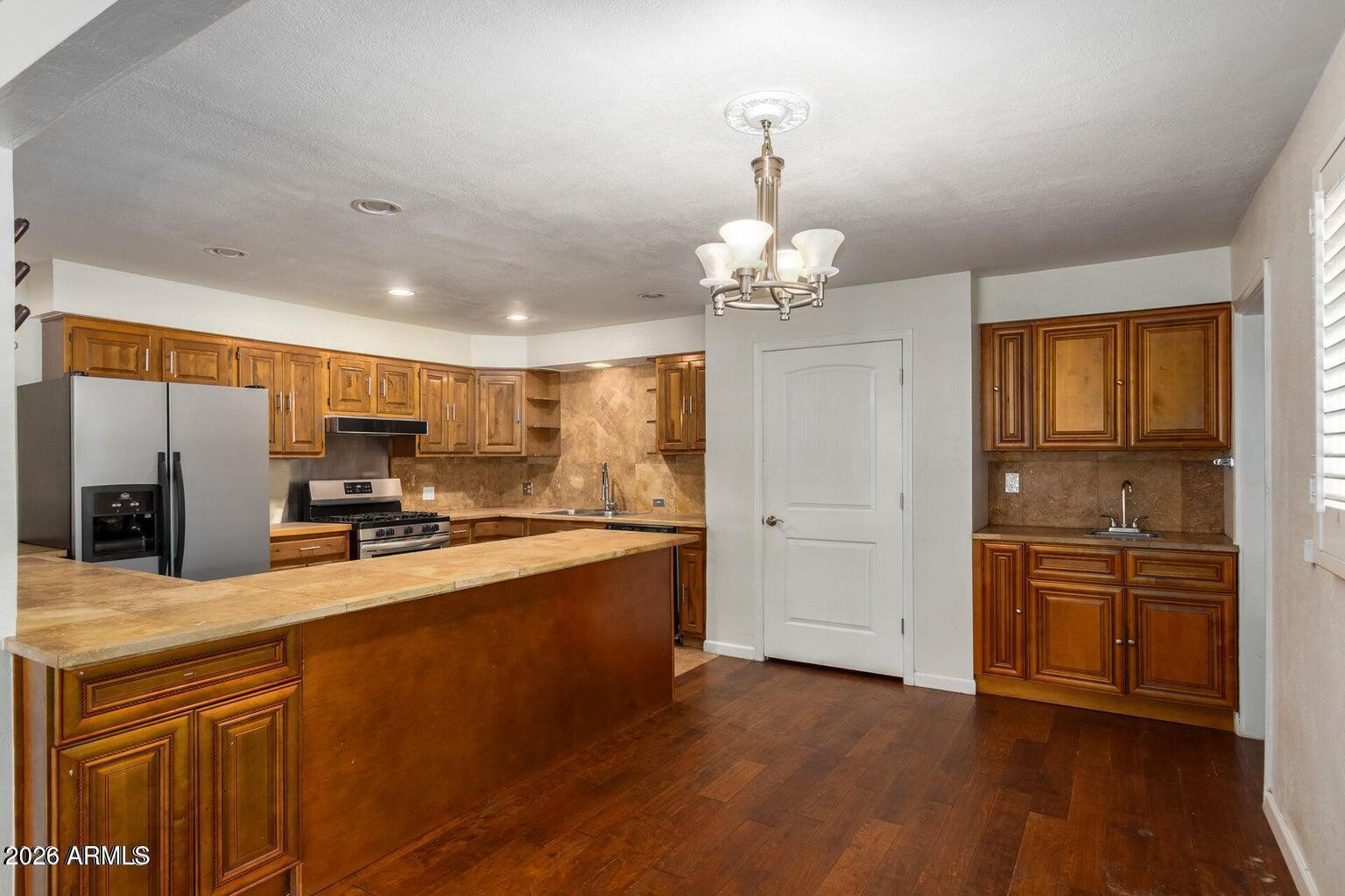 7340 North 7th Avenue Phoenix, AZ 85021 - Photo 5 of 37 a large kitchen with stainless steel appliances granite countertop a stove and a wooden floors